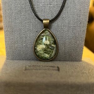 A black leather necklace with a white flower teardrop pendant